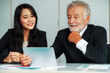 Senior executive manager and young businesswoman working in meeting room in the office. The woman...