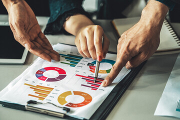 Businessman and businesswoman in meeting working with many financial statement document on desk. Concept of busy business profit analysis and brainstorm. Close up shot at people hands and papers. uds