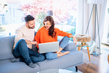 Couple at home using laptop and doing home budget