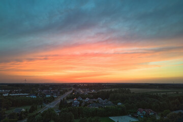 Dramatic sunset with rain and colorful clouds over fields