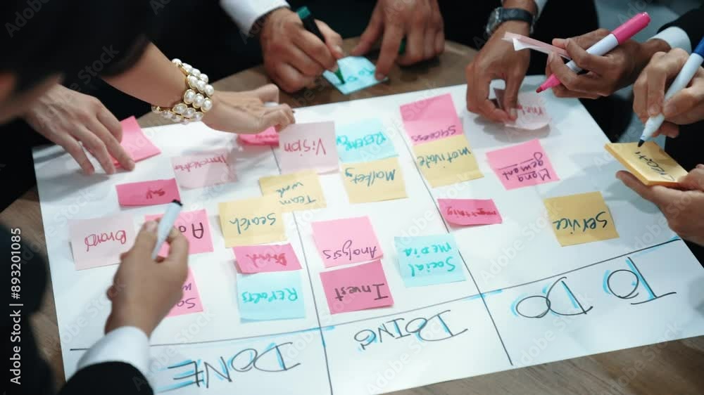 Poster close up of professional business team hands writing and putting sticky note on scrum task board. to