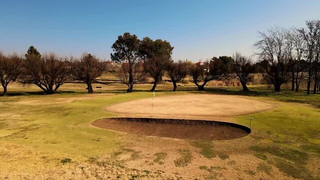 Golf course putting green, dry spell with a heat wave, with wilted, parched greens under the scorching sun and extreme conditions