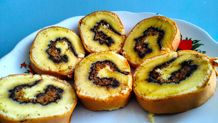 roll cake with chocolate peanut butter slice with blue plate