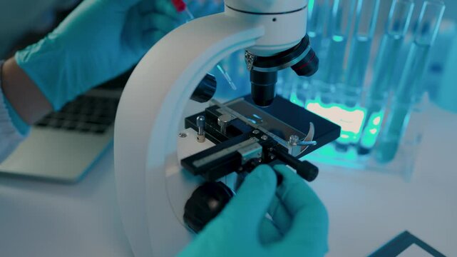a scientist is working in the laboratory and using microscope, a chemistry is very concentration on his work, science is always in our dairy life, wearing gloves while work in the lab