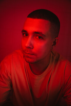 Man with buzz cut amidst red light
