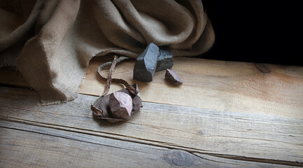 An antique leather sling lies on wooden desk