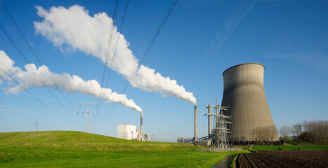 Electricity pylon station and steaming cooling towers in Netherlands