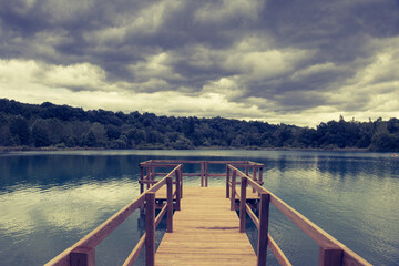 Naklejka premium ponton de pêche sur le lac de Virieu le grand dans l'ain un jour d'orage