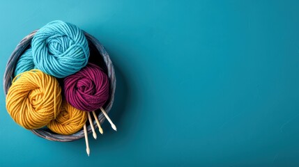 Colorful yarn balls in blue, yellow, and purple with crochet hooks in a basket on a turquoise background, perfect for knitting and crochet projects.