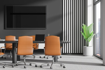 Dark conference interior with table and armchairs, tv display and window