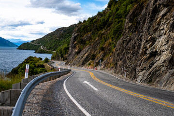 A camper van parked in an open field with mountains in the background. The clear sky and green landscape create an ideal setting for adventure, travel, and nature themes.