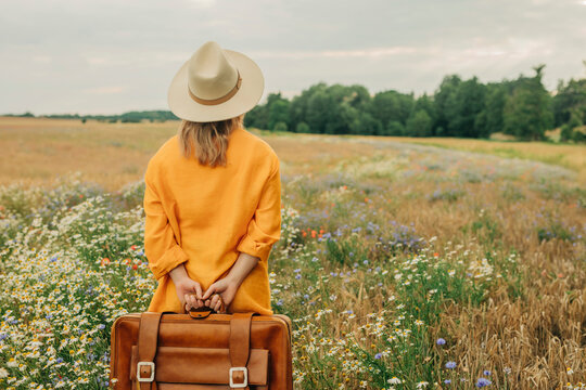 Woman standing with briefcase at chamomile field