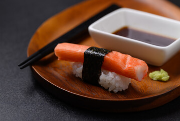Nigiri sushi crab stick on wooden plate with wasabi and sauce, Japanese food