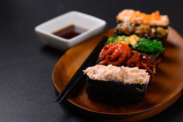 Gunkan maki sushi set on wooden plate with chopsticks and sauce, Japanese food