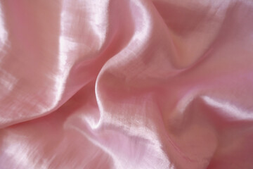 Pastel pink satin polyester fabric in soft folds