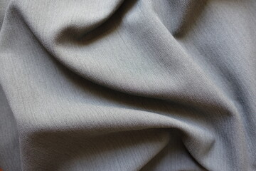 Folded light gray polyester fabric with herringbone pattern