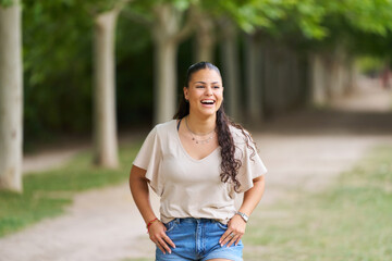 Fototapeta premium A woman with long hair is smiling and walking down a path