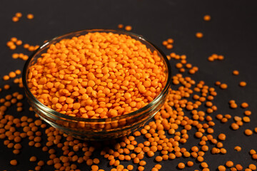 Red lentils in glass bowl. Dry orange lentil grains, heap of dal, raw daal, dhal, masoor