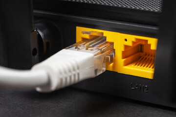 Connect an Ethernet Cable to a Wireless Router on dark. Ethernet, rj45 and electric cables,...