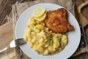 Swabian potato salad with vinegar, oil and broth. Served with a delicious cutlet on a plate