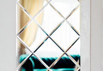Close-up of Geometric Patterned Mirror with Diamond Shapes. Close-up view of a geometric patterned mirror featuring diamond shapes, adding a modern touch to the interior design.