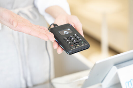 電子決済端末を持っている女性の手元