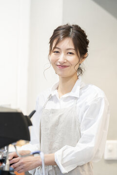 カフェで働いているエプロン姿の女性