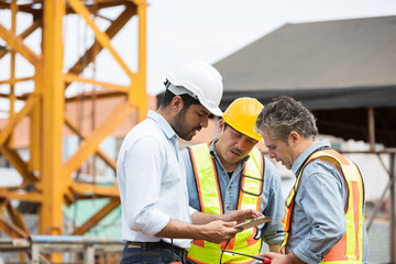 Team of male engineer construction working and discussing of structure of building at construction site. Group of male construction builder working at construction site