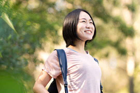バックパックを背負って森の中にいる女性