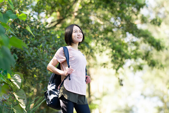 バックパックを背負って森の中にいる女性