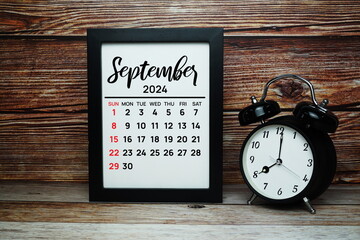 SEPTEMBER 2024 monthly calendar for planning and management concept with alarm clock on wooden...