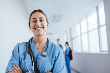 Caucasian healthcare student standing in a hospital during training, wearing scrubs and a stethoscope