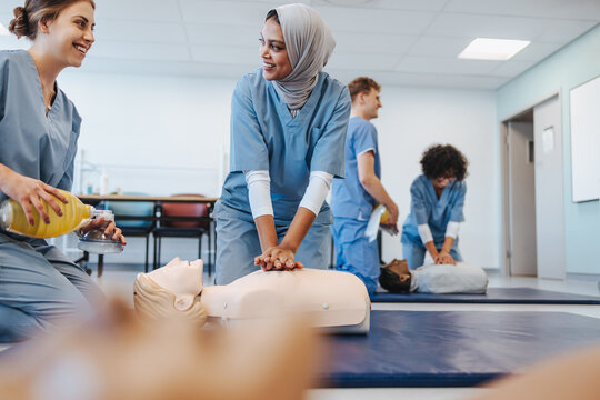 Female medical students performing CPR on a dummy in a teaching hospital