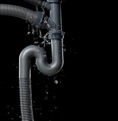 Leaking water from gray plastic pipe under sink. Drain leak water from pipe plumbing in bathroom as...