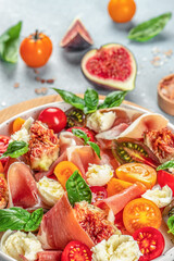 Fresh salad with figs, mozzarella, figs, prosciutto, fresh basil leaves and tomato, Concept healthy and balanced eating