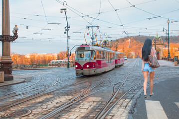 Red tram passing on  Bridge and famous Prague Castle on the background in Prague, Czech Republic.