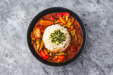 vegetable curry with rice dome in the middle topped with coriander
