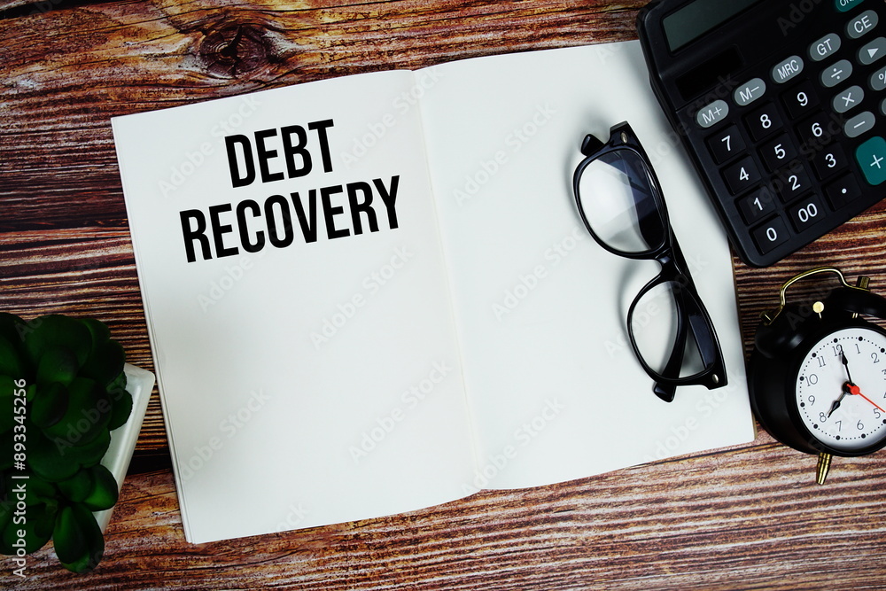 Aufkleber debt recovery text on note page with alarm clock and calculator top view on wooden background