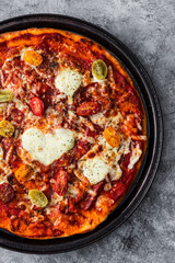 margherita pizza with cherry tomatoes and heart shaped cheese in the middle