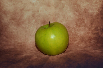 a green apple on a brown background