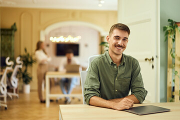 Fototapeta premium Portrait of a smiling man, working in a co-working space.