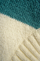 Detalle de tcuello en jersey de lana blanco y verde