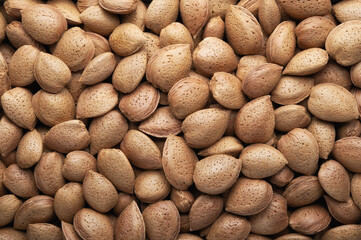 Heap of almonds in shell, top view, close-up.