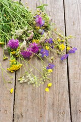 Colorful bouquet of meadow flowers on chalkboard background with empty space. Summer solstice bouquet. Top view, shallow depth of field.