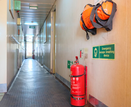 Emergency escape breathing device EEBD and fire extinguisher placed in passageway of cargo ship accommodation
