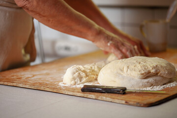 Women's hands make pasty dough