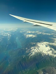 Obraz premium view from airplane window of alpine mountains covered with snow