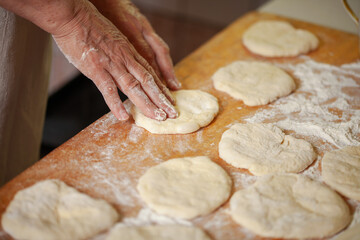 Women's hands make pasty dough