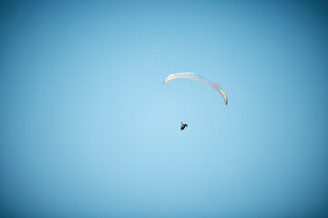 Space, parachute or person paragliding in blue sky for holiday, flight freedom or courage with...