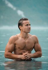Model swimming in a lake with bluish water, in the middle of nature.